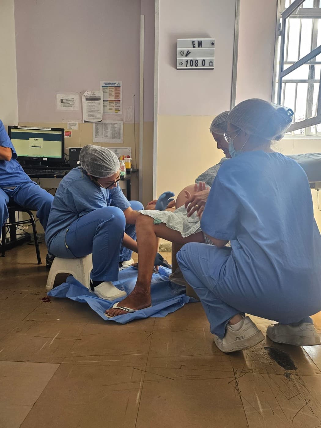 Chayene Rocha apoiando uma mulher durante o trabalho de parto, ao lado da equipe